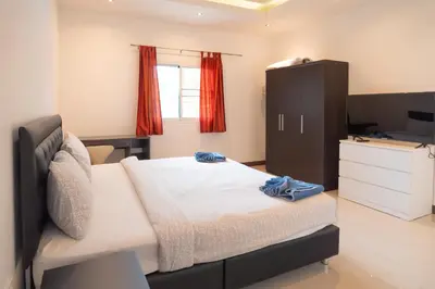 a bedroom with a bed and a dresser and a television at JUNGLE APARTMENT2 BEDROOMS PRIVATE POOl in Kamala Beach