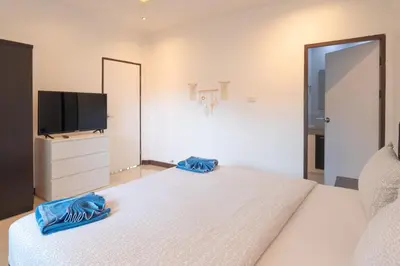 a bedroom with a large bed with a flat screen tv at JUNGLE APARTMENT2 BEDROOMS PRIVATE POOl in Kamala Beach