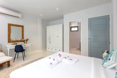 a white bedroom with a white bed and a desk at Kamala Beach House - 1 min walk to beach in Kamala Beach