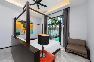 a bedroom with a bed and a chair and a window at VILLA Galam 2BR Private Pool Naiharn beach in Nai Harn Beach