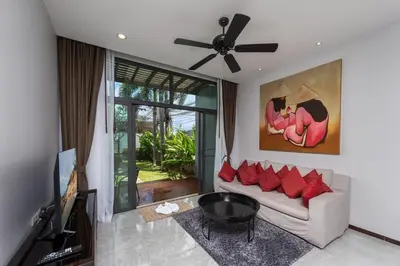 a living room with a couch and a tv at VILLA ATA Private Pool Nai harn beach in Nai Harn Beach
