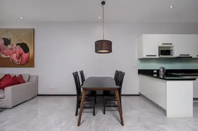 a kitchen with a table and chairs in a living room at VILLA ATA Private Pool Nai harn beach in Nai Harn Beach