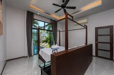 a bedroom with a bed and a ceiling fan at VILLA ATA Private Pool Nai harn beach in Nai Harn Beach