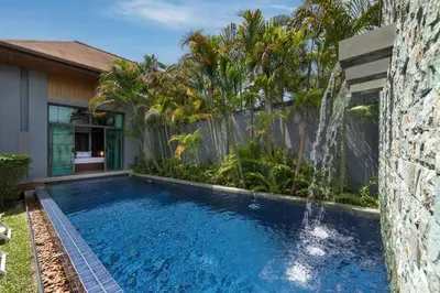 a swimming pool with a waterfall next to a house at VILLA ATA Private Pool Nai harn beach in Nai Harn Beach