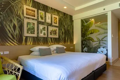 a bedroom with a large white bed with pictures on the wall at Panan Krabi Resort in Ao Nang Beach