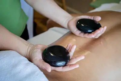 a person holding black balls in their hands at Panan Krabi Resort in Ao Nang Beach