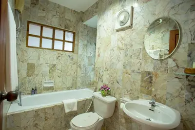 a bathroom with a toilet and a tub and a sink at Bangtao Village Resort - SHA in Bang Tao Beach