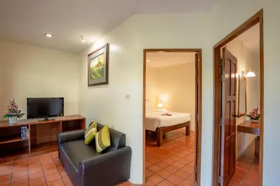 a living room with a couch and a television at Bangtao Village Resort - SHA in Bang Tao Beach