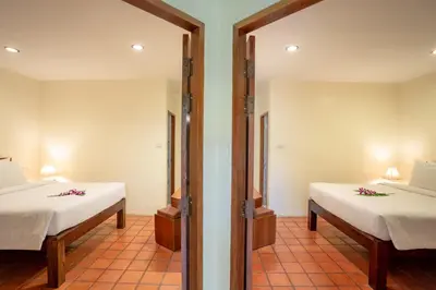 a room with two beds and a mirror at Bangtao Village Resort - SHA in Bang Tao Beach