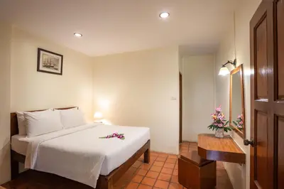 a bedroom with a white bed with flowers on it at Bangtao Village Resort - SHA in Bang Tao Beach