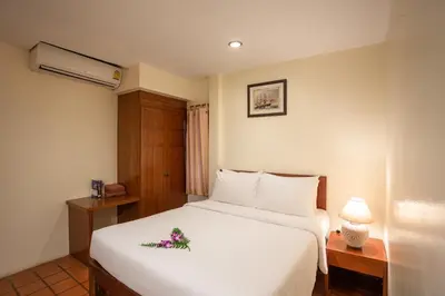 a bedroom with a white bed with flowers on it at Bangtao Village Resort - SHA in Bang Tao Beach