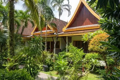 a house with trees and plants in front of it at Bangtao Village Resort - SHA in Bang Tao Beach