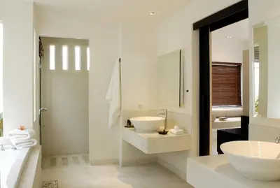 a white bathroom with a sink and a mirror at The Racha in Ko Racha Yai