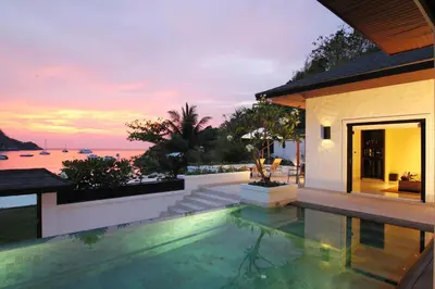 a villa with a swimming pool with a view of the ocean at The Racha in Ko Racha Yai