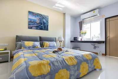 a bedroom with a bed with a yellow and blue comforter at YaYa B By Briza Group in Chalong