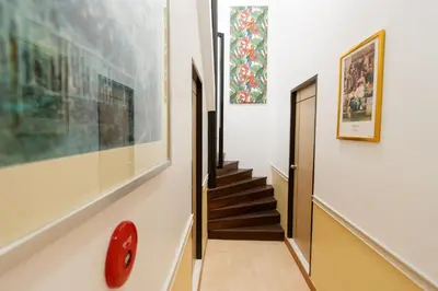 a hallway with stairs and paintings on the wall at YaYa B By Briza Group in Chalong