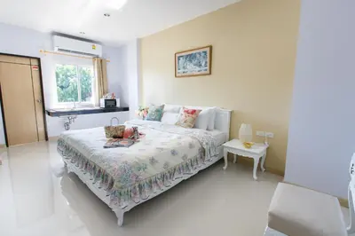 a white bedroom with a bed and a window at YaYa B By Briza Group in Chalong