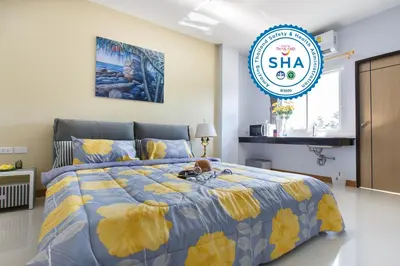 a bedroom with a bed with a blue and yellow bedspread at YaYa B By Briza Group in Chalong