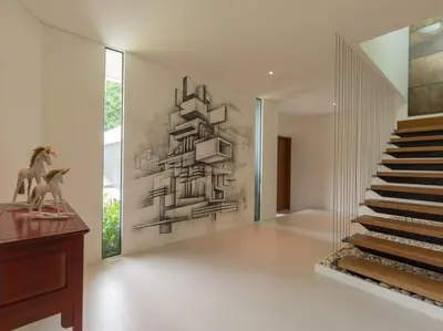 a staircase in a house with a painting on the wall at Villa Abiente in Thalang