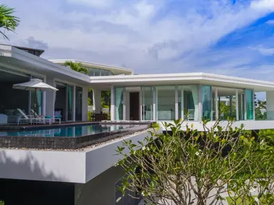 an exterior view of a house with a swimming pool at Villa Abiente in Thalang