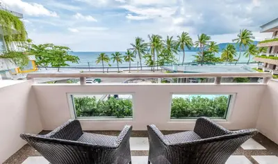 a balcony with two chairs and a view of the ocean at Homm Bliss Southbeach Patong in Patong Beach