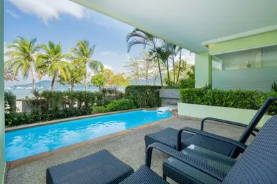 a house with a swimming pool and two chairs at Homm Bliss Southbeach Patong in Patong Beach