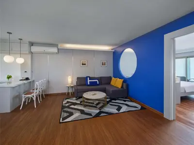 a living room with a couch and a blue wall at Homm Bliss Southbeach Patong in Patong Beach
