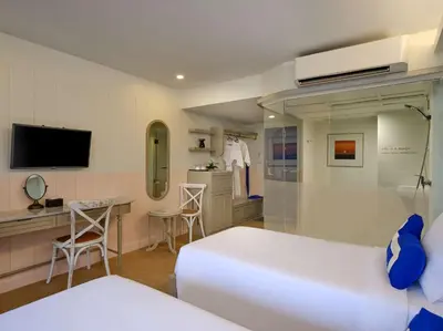 a bedroom with a bed and a desk and a tv at Homm Bliss Southbeach Patong in Patong Beach