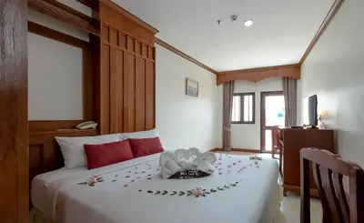 a bedroom with a white bed with flowers on it at Tony Resort in Patong Beach