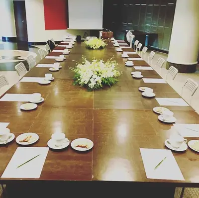 a long table with white plates and flowers on it at I Pavilion Hotel Phuket in Phuket Town