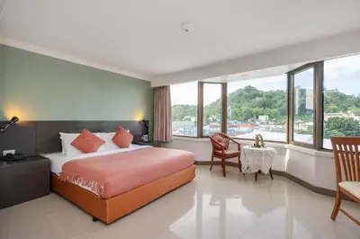 a bedroom with a bed and a table and chairs at I Pavilion Hotel Phuket in Phuket Town