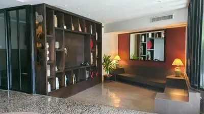 a living room with a large wooden book shelf at I Pavilion Hotel Phuket in Phuket Town