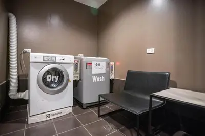 a washing machine and a chair in a room at I Pavilion Hotel Phuket in Phuket Town