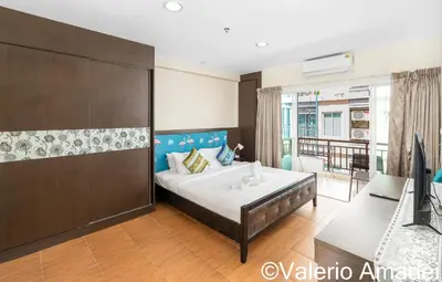 a bedroom with a bed and a desk and a television at Phuket Villa Patong Beach by PHR in Patong Beach