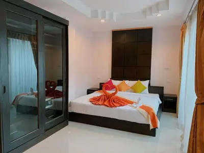 a bedroom with a bed with an orange dress on it at Ice Kamala Beach Hotel in Kamala Beach