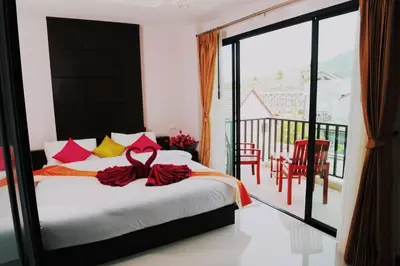 a bedroom with a bed and a balcony at Ice Kamala Beach Hotel in Kamala Beach