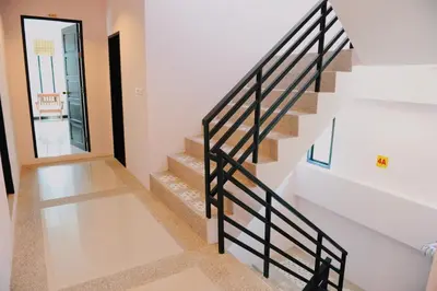 a staircase with a black railing in a house at Ice Kamala Beach Hotel in Kamala Beach