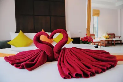 two pink flamingos are sitting on a bed at Ice Kamala Beach Hotel in Kamala Beach