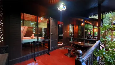 a house with a balcony with a bed and a table at Baan Habeebee Resort in Ao Nang Beach