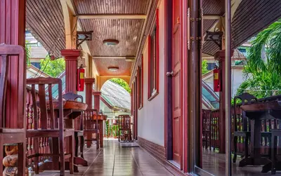 an empty corridor of a building with tables and chairs at Kata Leaf Resort Phuket - in Kata Beach