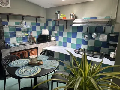 a kitchen with a table and chairs in a kitchen at Kata Leaf Resort Phuket - in Kata Beach