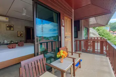 a room with a bed and a balcony at Kanya Cozy Bungalows Kata in Kata Beach