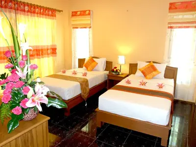 a hotel room with two beds and flowers in it at Aonang Lake Side in Ao Nang Beach