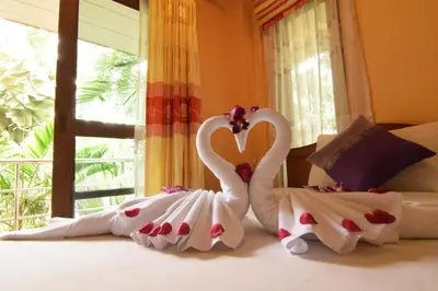 two swans dressed in white sitting on a bed at Aonang Lake Side in Ao Nang Beach
