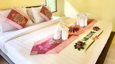 two beds with towels and flowers on them at Sawaddee Aonang Resort in Ao Nang Beach