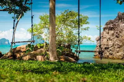 a swing by the water with rocks and trees at Krabi Home Resort in Tab Kaek Beach