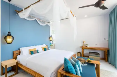 a bedroom with a bed and a blue wall at Krabi Home Resort in Tab Kaek Beach