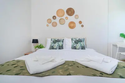 a bed with two white towels on top of it at ZcapeX2 in Bang Tao Beach