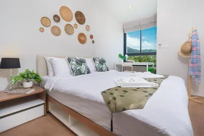 a bedroom with a bed and a desk and a window at ZcapeX2 in Bang Tao Beach