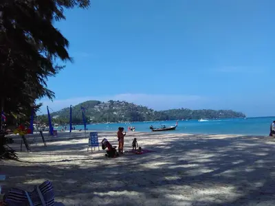 a man and a child standing on a beach at KD Residence in Bang Tao Beach